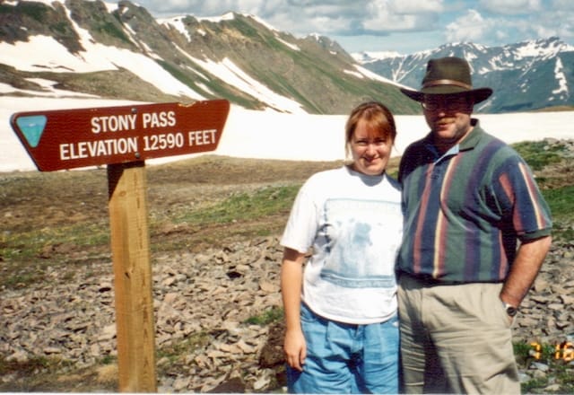 A picture of me and my husband in front of a sign that says Stony Pass Elevation 12590 feet