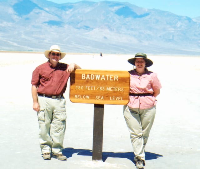 Me and my husband in front of the Badwater elevation sign in Death Valley 